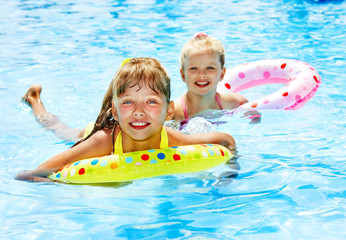 Children sitting on inflatable ring.