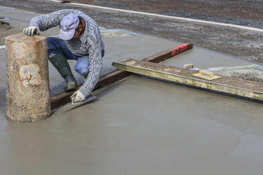 ouvrier posant une chappe en b&eacute;ton