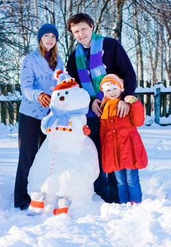 Family With Snowmen In Garden