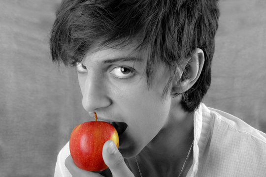 Portrait garçon n&b croquant une pomme rouge