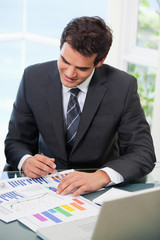 Man sitting on a chair while looking at graph