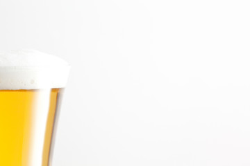 Glass of beer and foam against a white background