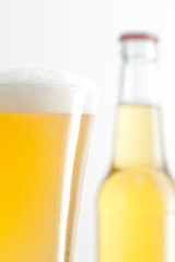 Bottle and glass of beer against a white background