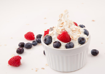 White jar of berries and whipped cream