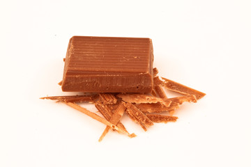 Piece of milk chocolate on chocolate shavings