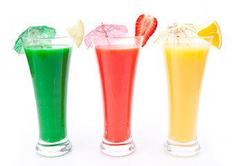 Fruit pieces and cocktail umbrella in a row of glasses