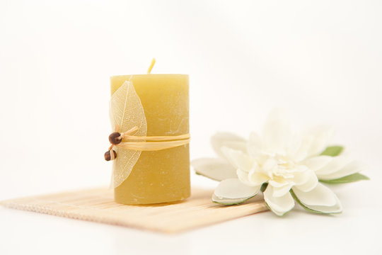Yellow candle with a white flower