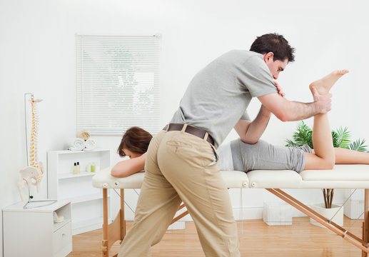 Brunette woman being stretched by a physiotherapist