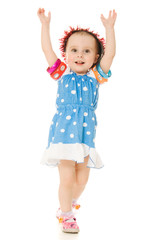 The little girl in hat is dancing