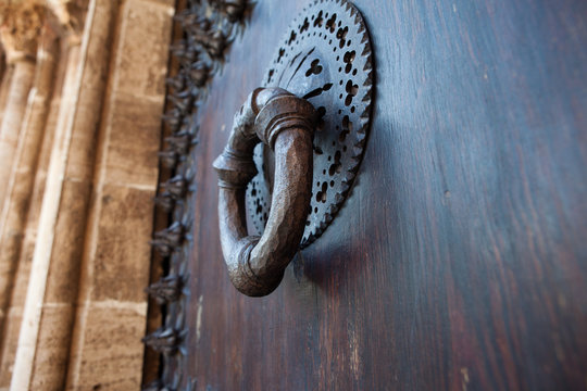 Aldaba de hierro en puerta de madera de un monasterio