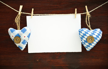 2 Stoffherzen mit Blankokarte auf Holzbrett