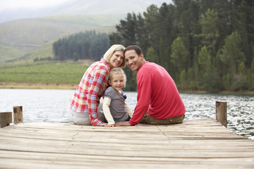Fototapeta premium Young family sitting on a jetty