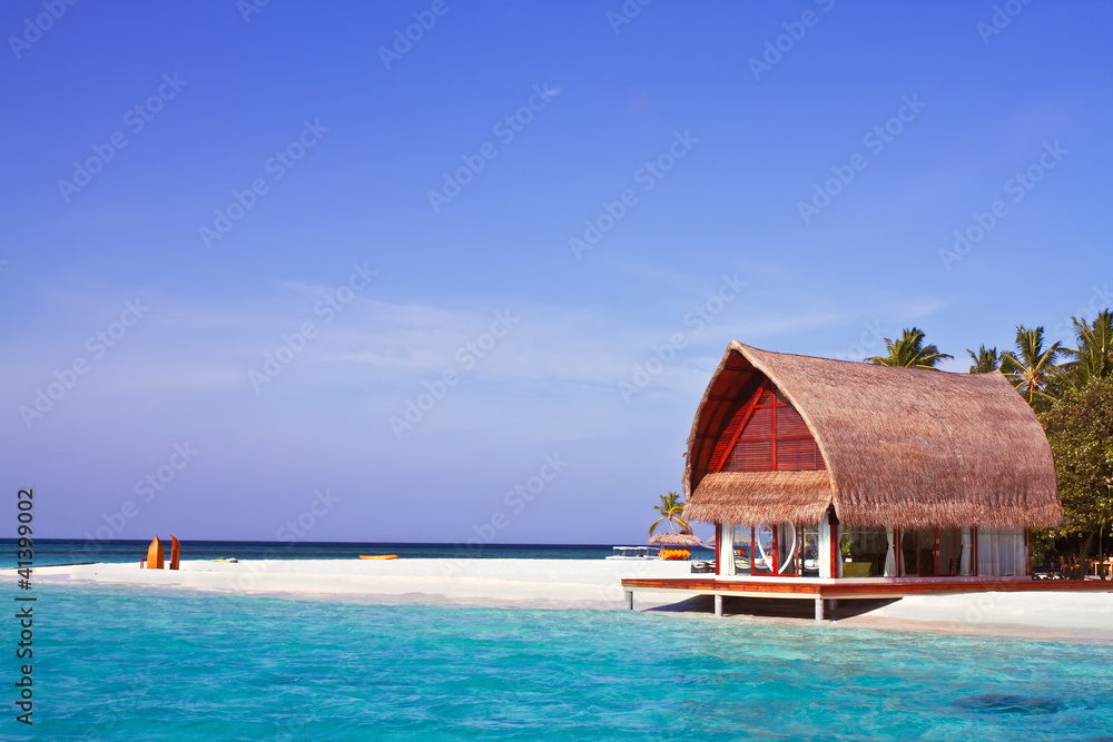 Wall mural landscape photo of beach house in maldive ocean with blue sky