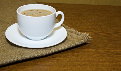 Hot cup of coffee on sack