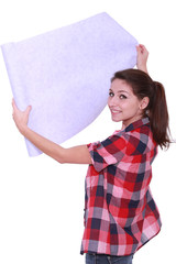 Young woman unrolling wallpaper