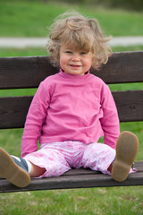 girl is sitteing on a park bench