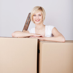blonde junge frau mit umzugskartons