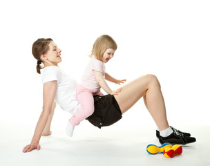 Young mother doing sport exercises with her little daughter