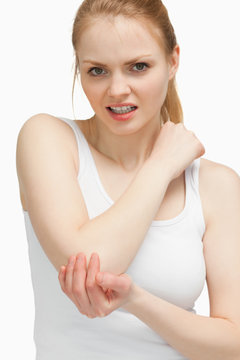 Blonde woman touching her painful elbow