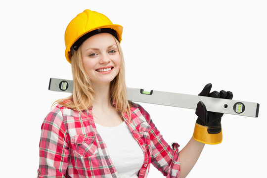 Smiling woman holding a spirit level