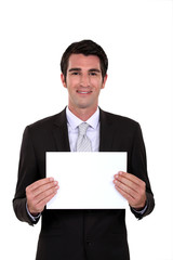 A businessman holding a blank poster.