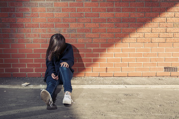 Girl against the wall with syringe & cigarettes.  Horizontal.
