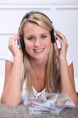 Naklejka premium A blond woman, smiling at us, with CDs in front of her.