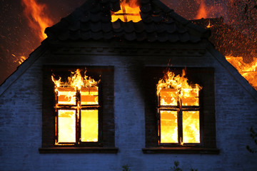 Burning in wild flames. House on fire. Dangerous blaze
