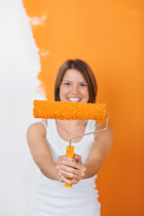 lachende frau mit farbrolle