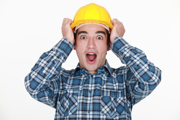 young craftsman shouting with hands to hardhat