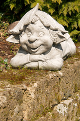 clay dwarf on a mossy stone wall