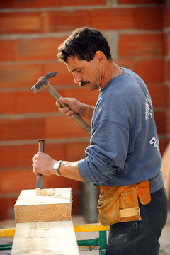 Man using chisel and haller on wooden block
