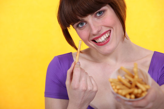 Young Woman Eating French Fries