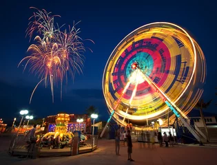 Foto auf Leinwand Vergnügungspark bei Nacht - Riesenrad in Bewegung und Feuerwerk © noomhh