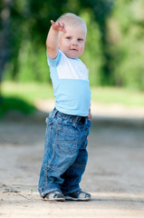 Fototapeta premium Happy little boy in the green park