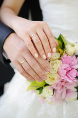 Obraz na płótnie Canvas Ręce i pierścienie na bukiet ślubny