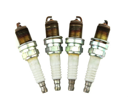 Four Old Burned Spark Plug On White Background