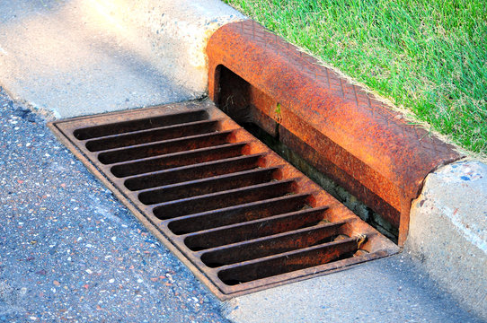 storm sewer by footpath, storm drain system, street gutter with rusty cover