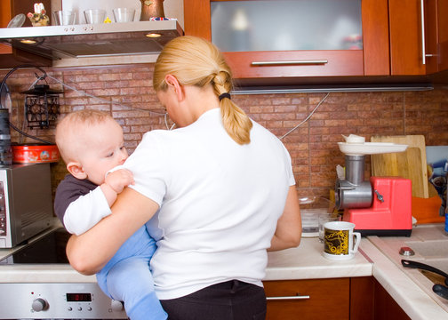 Woman in kitchen with a baby
