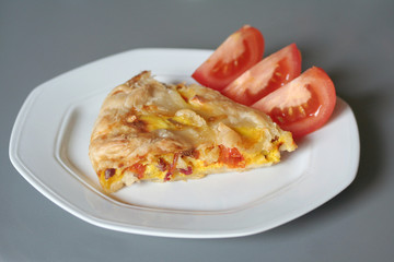 torta salata con fette di pomodoro su piatto
