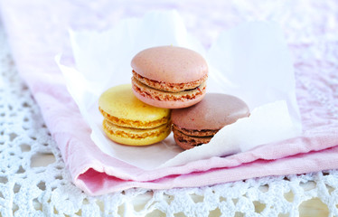 Lemon, raspberry, chocolate macaroons biscuits on a pink napkin