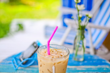 ice coffee on grunge wood table in garden