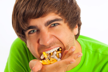 Young man feeding himself pills