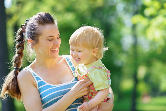 Happy Mother Tickling Baby Outside