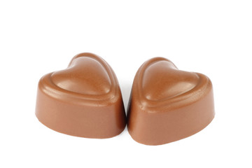 Two heart chocolate candies on white background