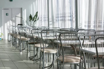 Deurstickers Photo of a canteen with metal chairs and tables © Sved Oliver