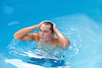 Mann im Pool macht Haare nass