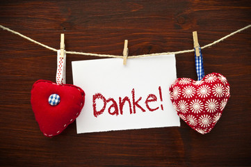 2 Stoffherzen mit Karte und Danke auf Holzbrett