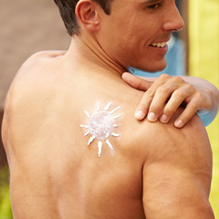 Mann mit Sonnencreme auf dem Rücken