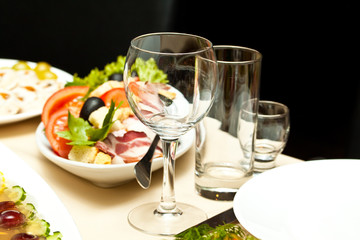Glasses and plates on table in restaurant - food background